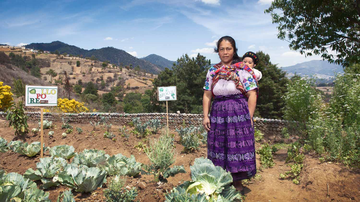 En kvinna med barn i en ekologisk trädgård i Guatemala