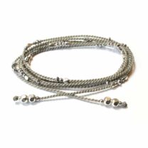 Grått Wakami-smycken med accenter av silverpärlor. Kan användas både som halsband och armband. Vackert smycke som gör gott.